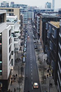 High angle view of vehicles on road along buildings