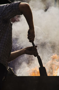 Worker holding tool by fire
