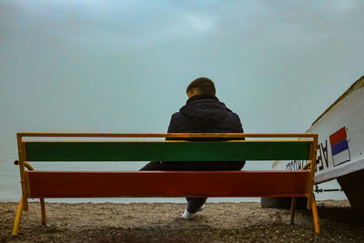 Rear view of man sitting on bench