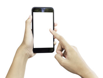 Close-up of hand holding mobile phone over white background