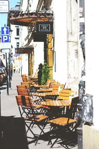 Chairs and tables at sidewalk cafe in city