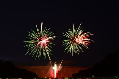 Low angle view of firework display against sky at night