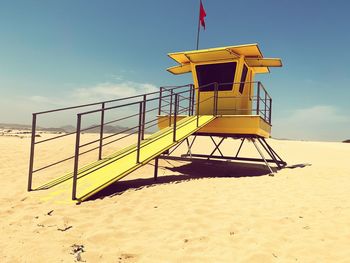 Lifeguard hut on beach against sky