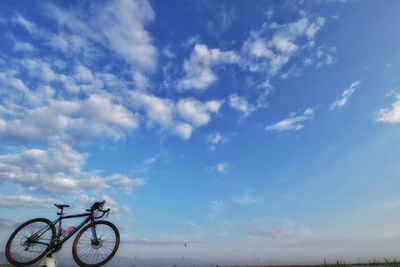 Low angle view of bicycle against blue sky