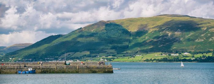 Boats in harbor in front of sea