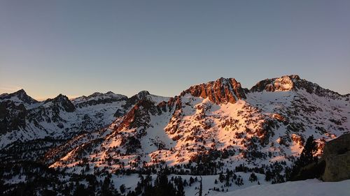 Scenic view of snowcapped mountains against sky during sunset