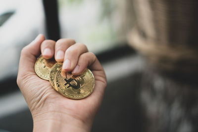 Cropped hand of person holding bitcoins