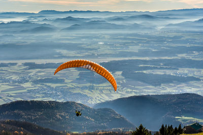 High angle view of person paragliding over mountains