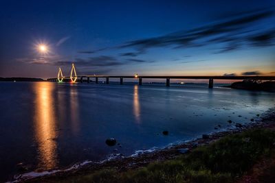 Bridge over sea against sky at night