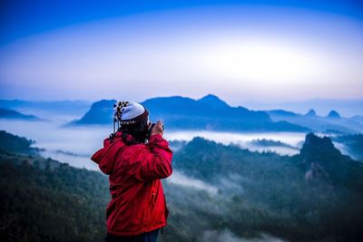 Man looking at mountain range against sky