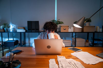 Midsection of woman using laptop at office