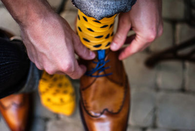 Close-up of man touching shoes on street