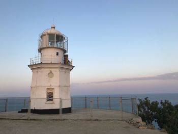 Lighthouse by sea against sky