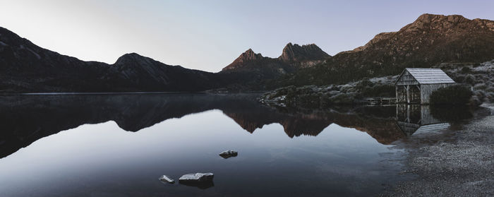 Scenic view of calm lake and mountains against sky