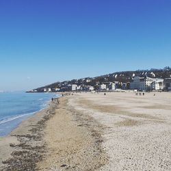 Scenic view of beach against clear blue sky