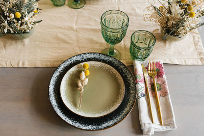 Rustic dining table setting two ceramic plates decorated with dried flowers