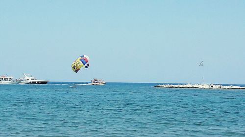 Boats in sea against clear sky