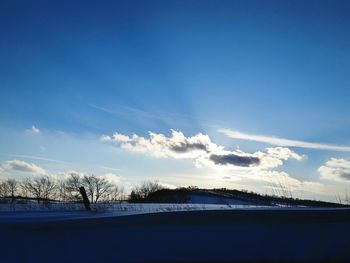 Scenic view of landscape against blue sky during winter