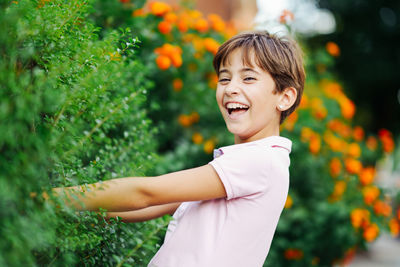 Portrait of smiling boy standing against plants