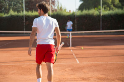 Men playing tennis in court