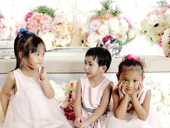Siblings against flower bouquets