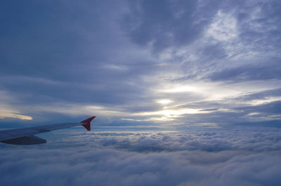 Airplane flying over cloudscape against sky