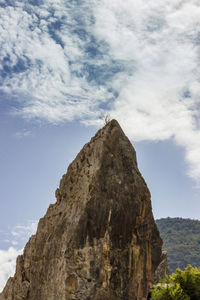 Low angle view of mountain against cloudy sky