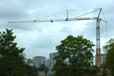 Low angle view of crane against sky