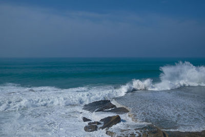 Scenic view of sea and waves against sky