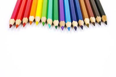 Close-up of multi colored pencils against white background