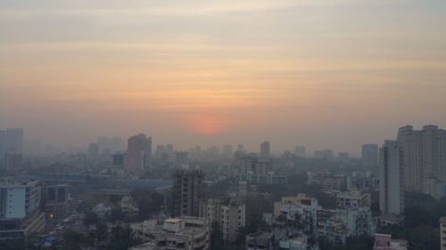 Cityscape against sky at sunset