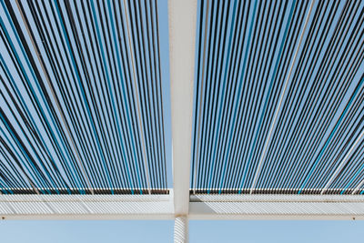 Low angle view of shade structure against clear blue sky