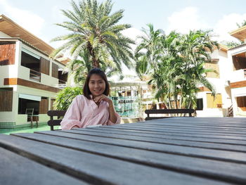 Portrait of woman sitting on palm tree