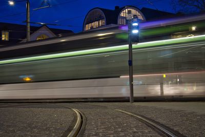 Train at railroad station platform at night