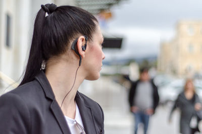 Close-up of businesswoman wearing headset while standing outdoors