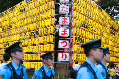 Portrait of people standing against yellow wall