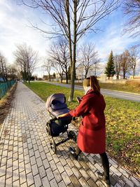 Rear view of woman on footpath against sky