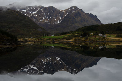 Scenic view of lake by mountains against sky