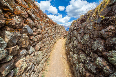 Empty narrow footpath amidst old ruins at pisac