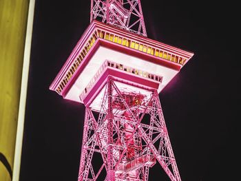 Low angle view of illuminated tower against sky at night