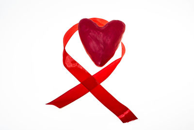 Close-up of red heart shape over white background