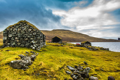 An old abandoned hamlet in the faroe islands. mountains and lake on background. high quality photo