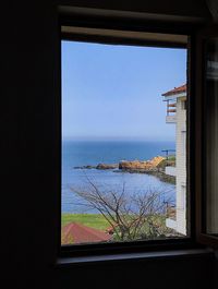 Scenic view of sea against clear sky seen through window