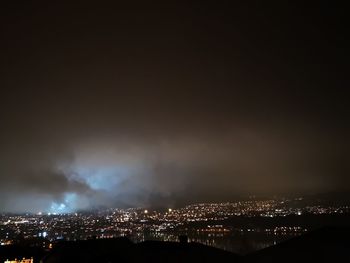 High angle view of illuminated city against sky at night