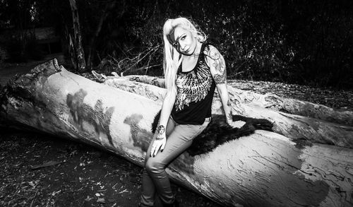 Portrait of smiling young woman against tree