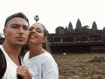 Young couple at temple against clear sky