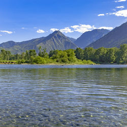 Scenic view of lake by mountains against sky