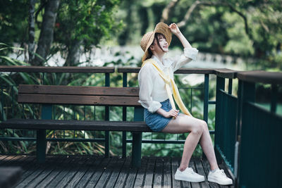 Young woman sitting on railing