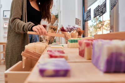 Midsection of woman holding ice cream for sale