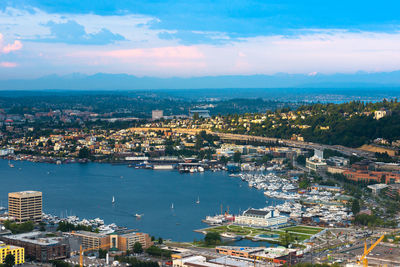 Aerial view of city by sea against sky